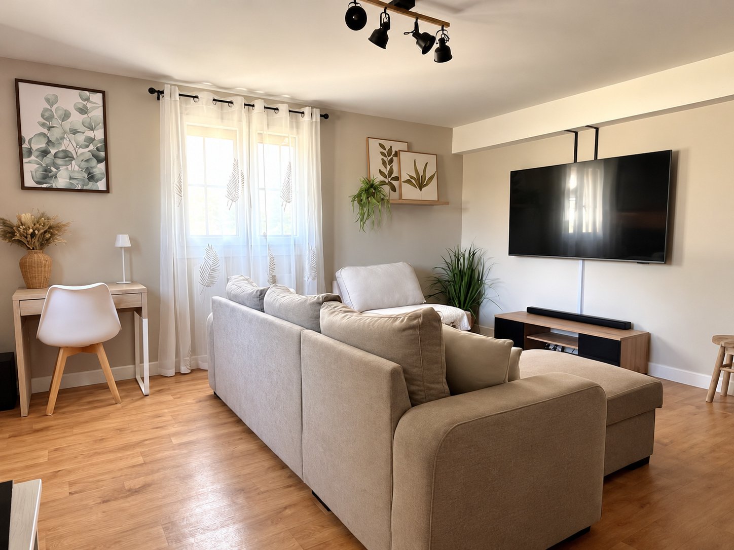 Salon avec canapé clair, télévision et décoration végétale