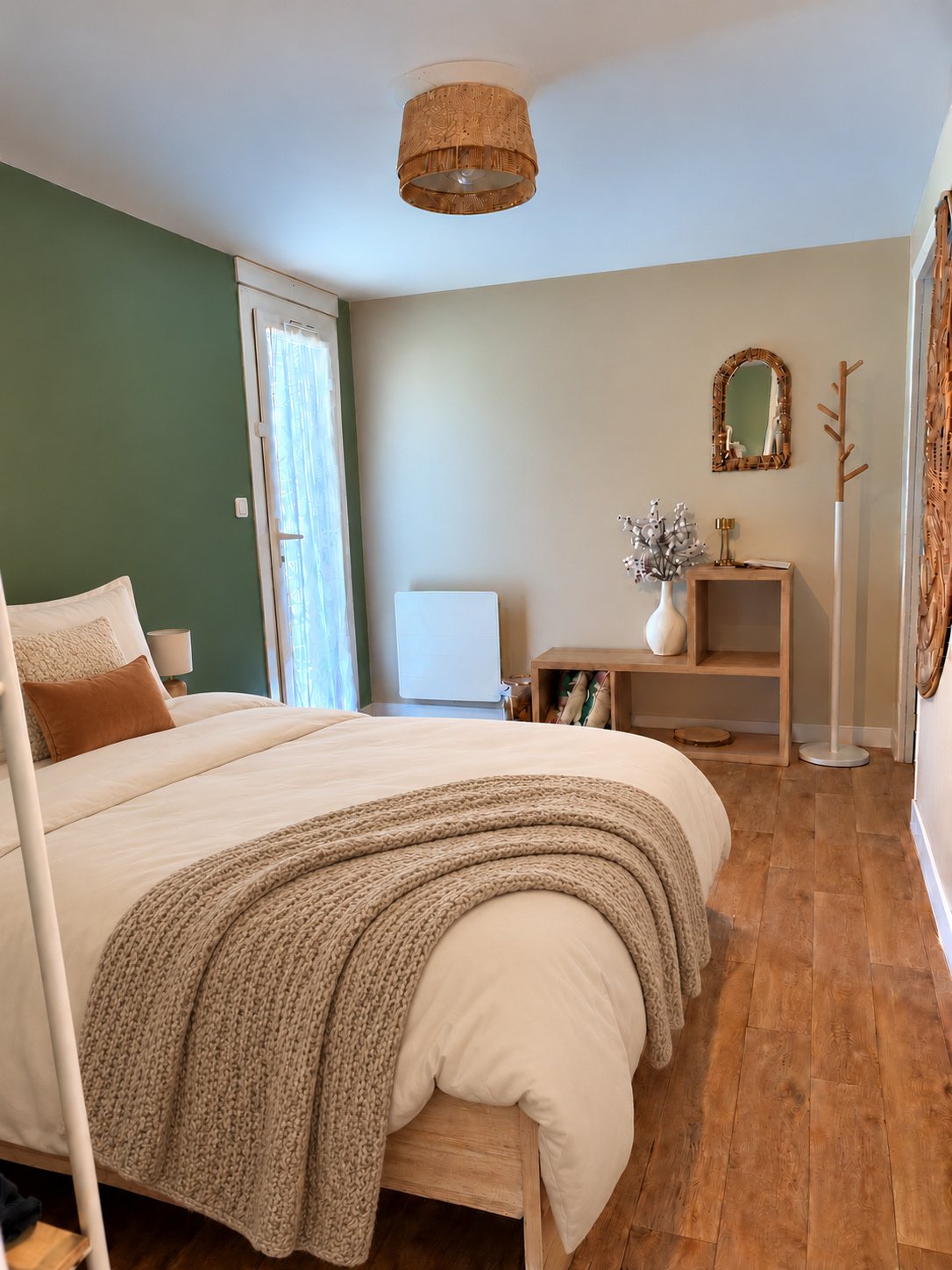 La chambre avec lit double, linge ivoire et décoration aux tons naturels
